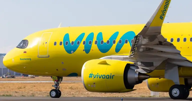 Avión amarillo y azul de aerolínea de bajo costo estacionado en pista de aeropuerto