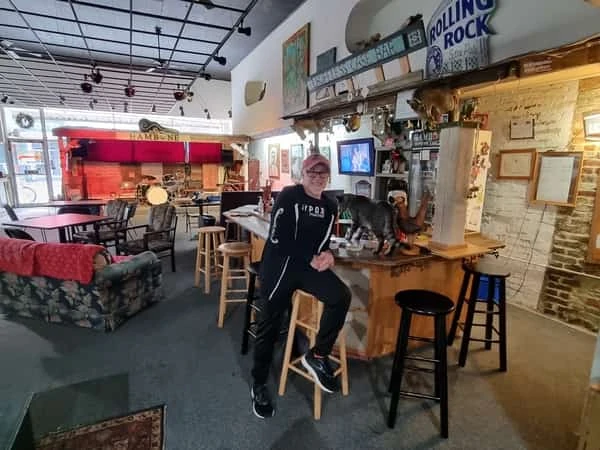 Interior de bar de blues con hombre de pie frente al mostrador