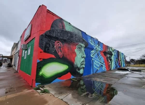 Mural callejero en Clarksdale con rostro artístico coloreado en rojo, azul y verde