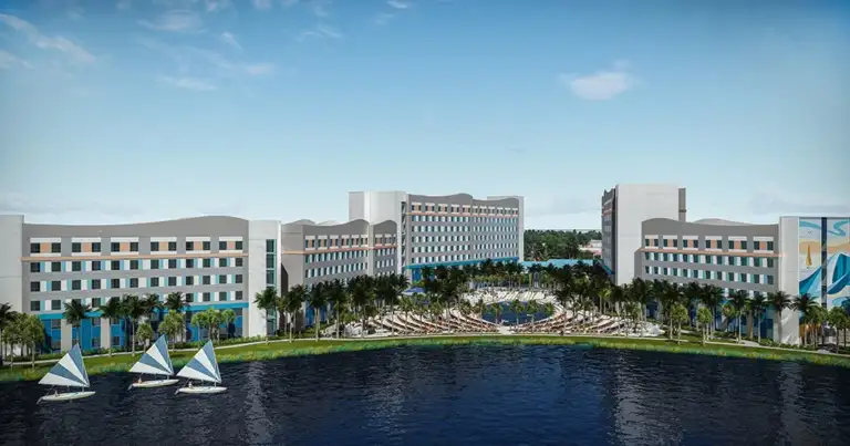 Complejo hotelero moderno frente a laguna artificial con esculturas azules