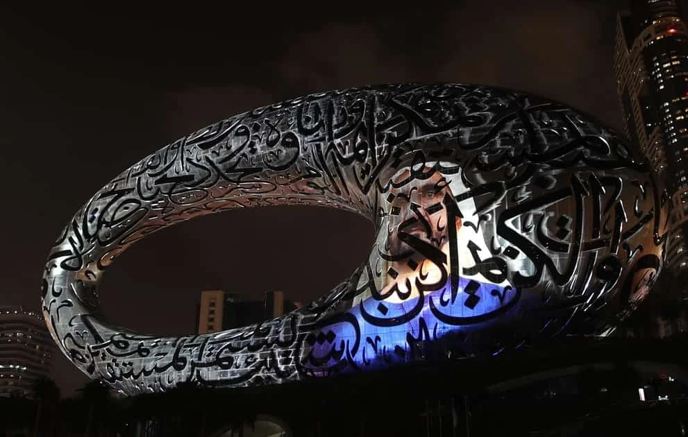 Estructura arquitectónica con caligrafía árabe iluminada en azul neón por la noche