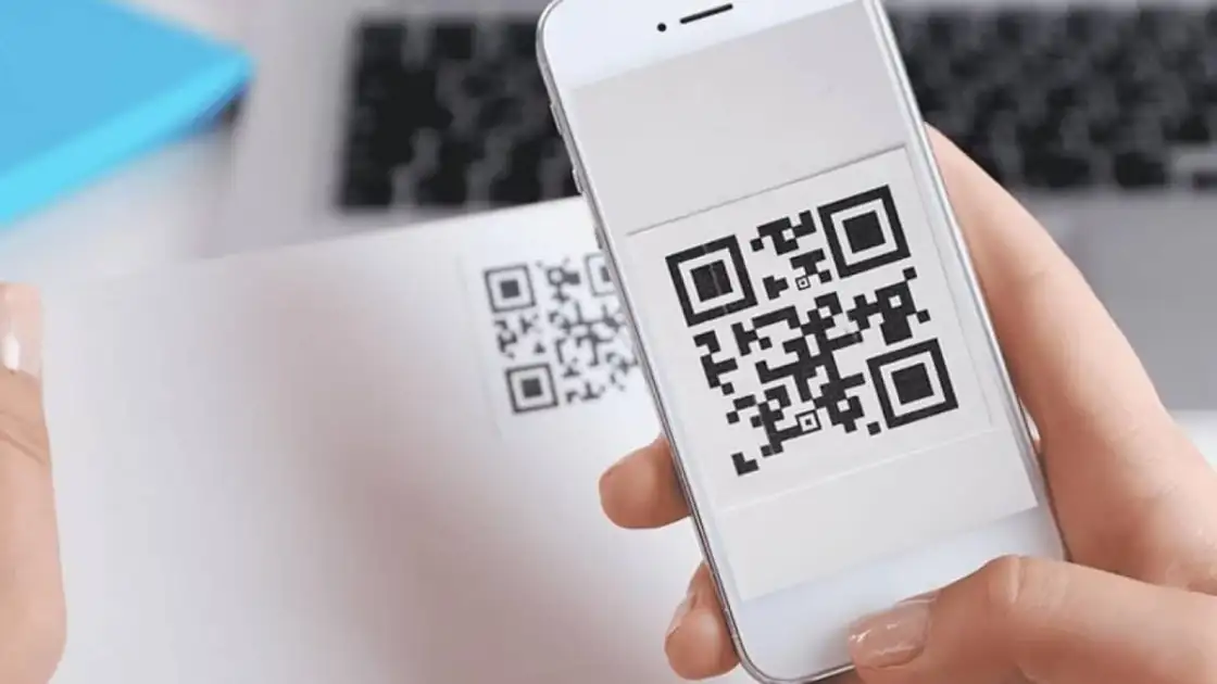 Mano sosteniendo teléfono con código QR en pantalla