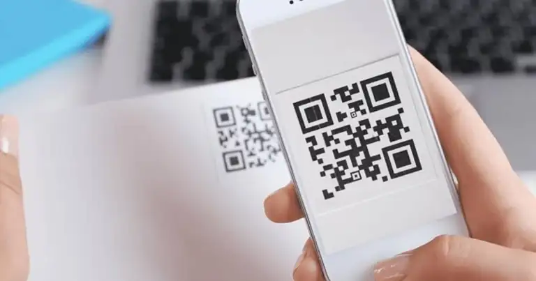 Mano sosteniendo teléfono con código QR en pantalla