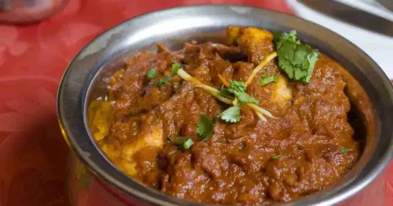 Plato de curry con cilantro fresco en recipiente metálico