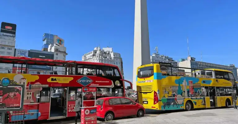 Buses turísticos frente al Obelisco de Buenos Aires en un día soleado