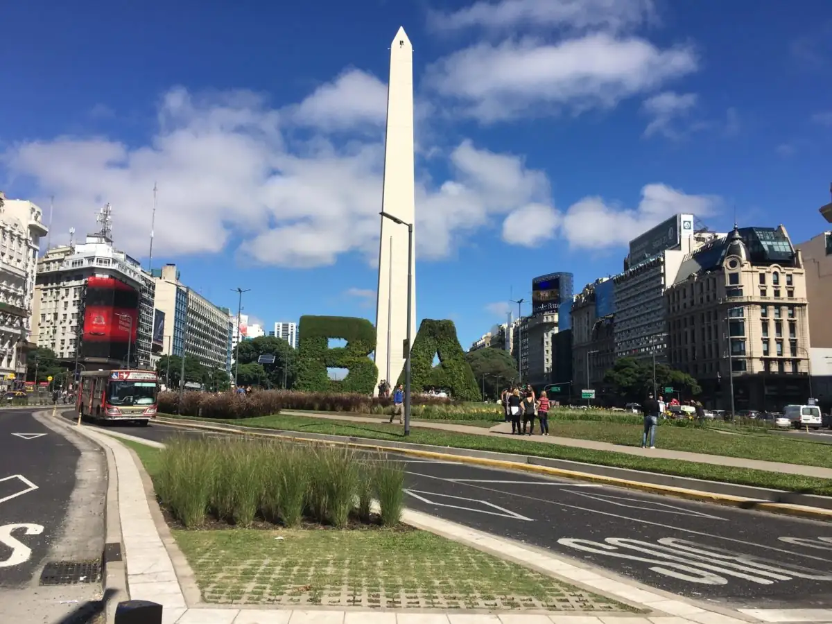 Obelisco blanco rodeado de avenidas y edificios urbanos