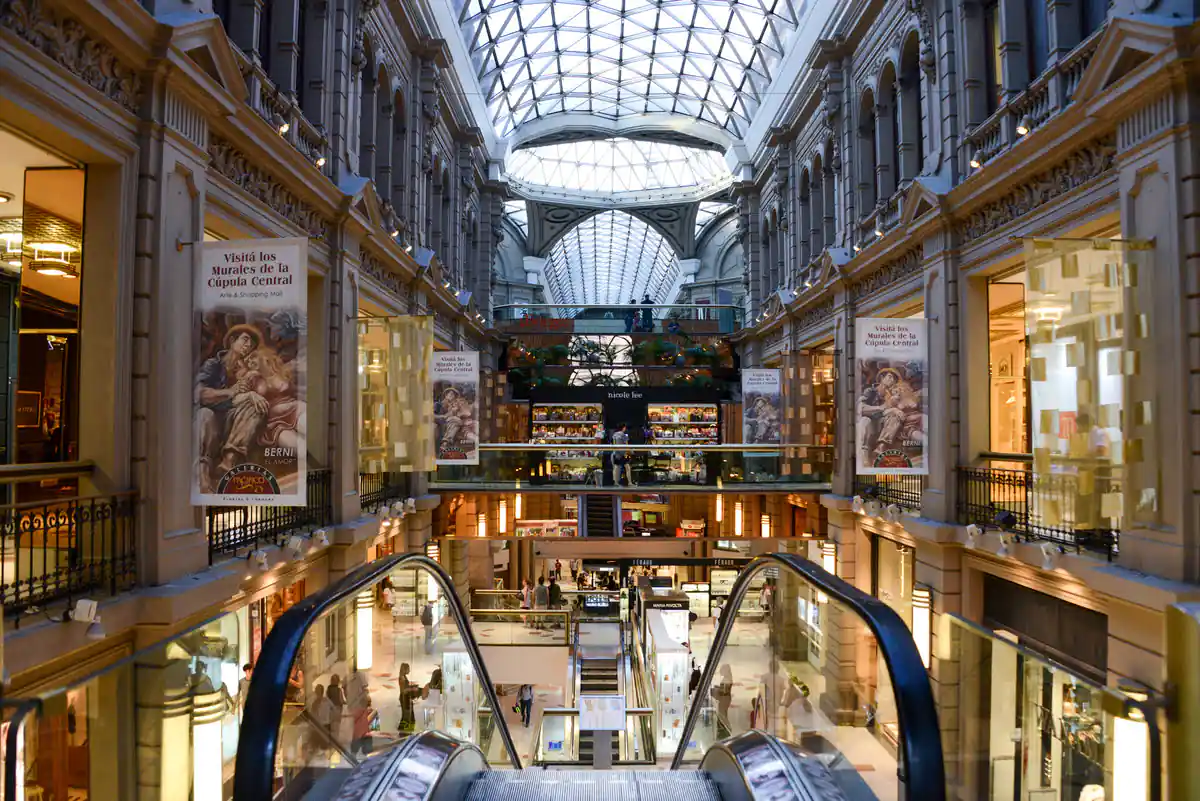 Interior de galería comercial con arquitectura clásica y claraboya