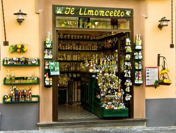 Tienda de licor italiano con rótulo El Limoncello y botellas en escaparate