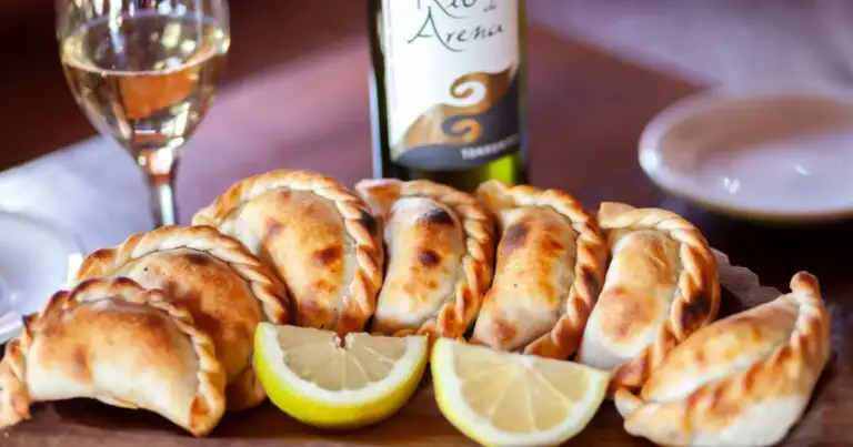 Empanadas doradas con limón y copa de vino blanco