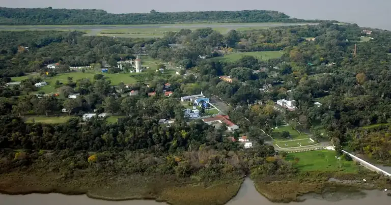 Vista aérea de isla con río, casas dispersas y vegetación