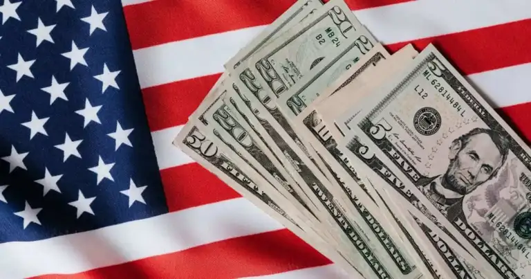 Billetes de dólar estadounidense sobre bandera americana