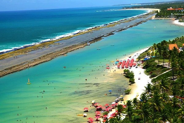 Playa tropical con aguas turquesas, arena blanca y arrecife visible