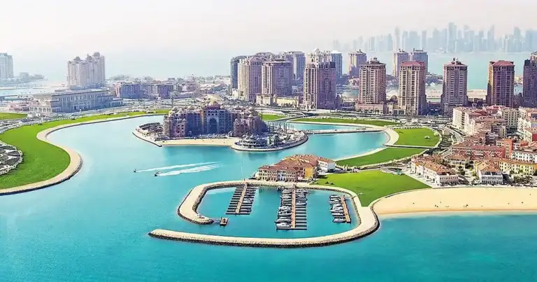 Playa con arena blanca y agua turquesa junto a edificios costeros