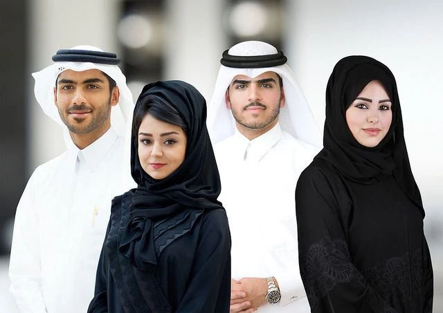 Cuatro personas con atuendos tradicionales árabes: dishdasha, ghutra y niqab