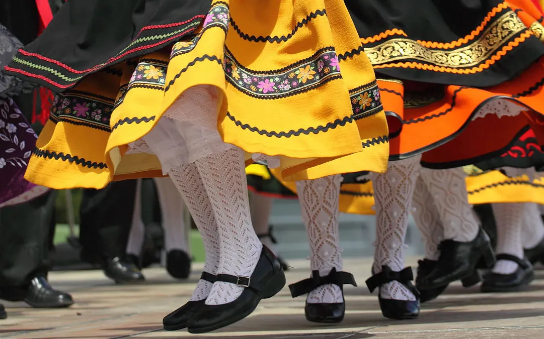 Danzas típicas de España Bailarinas españolas realizando danzas típicas con trajes tradicionales coloridos