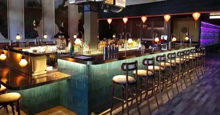 Interior de bar elegante con mostrador oscuro e iluminación cálida