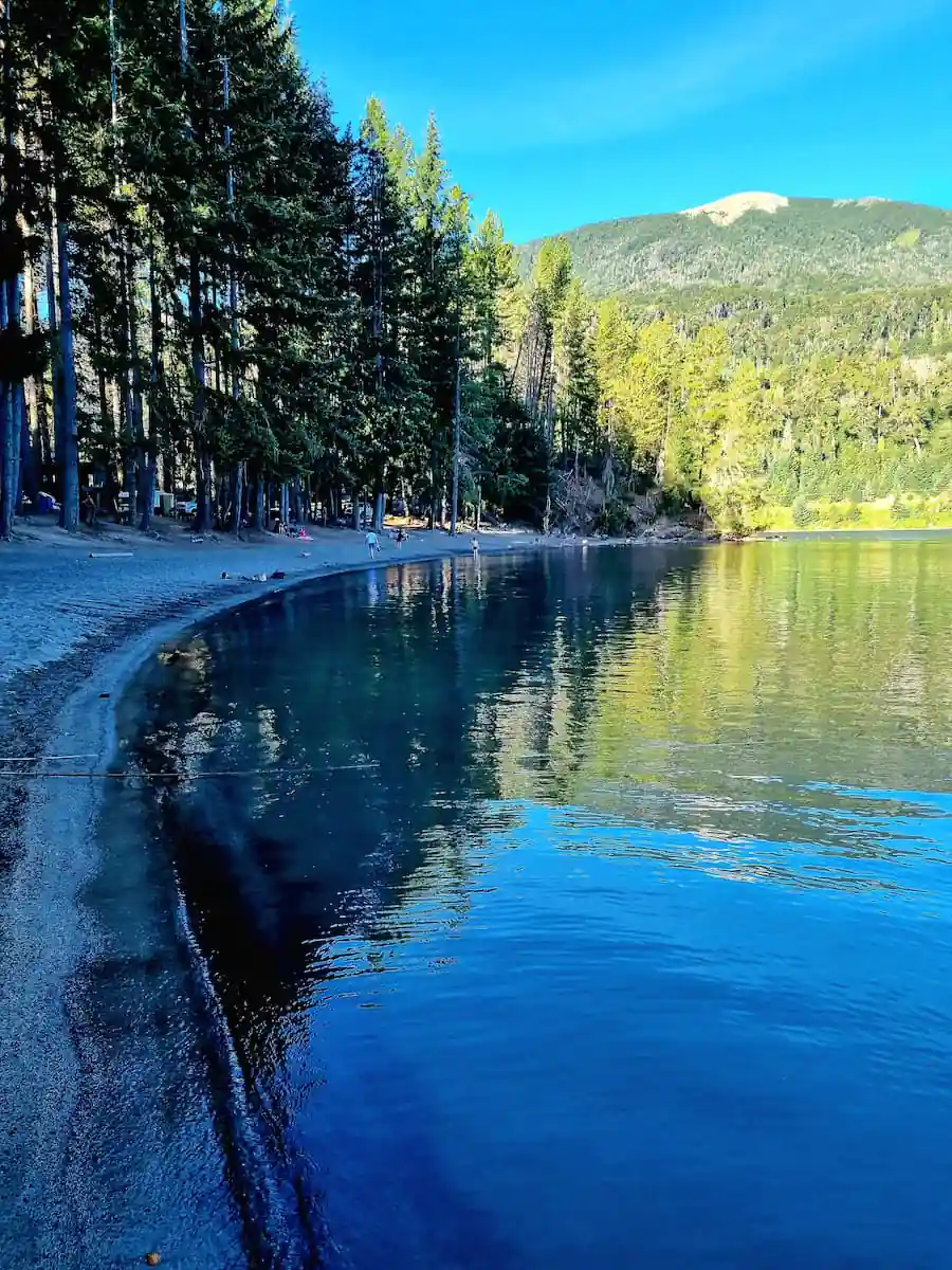 Lago tranquilo rodeado de bosque en Villa La Angostura