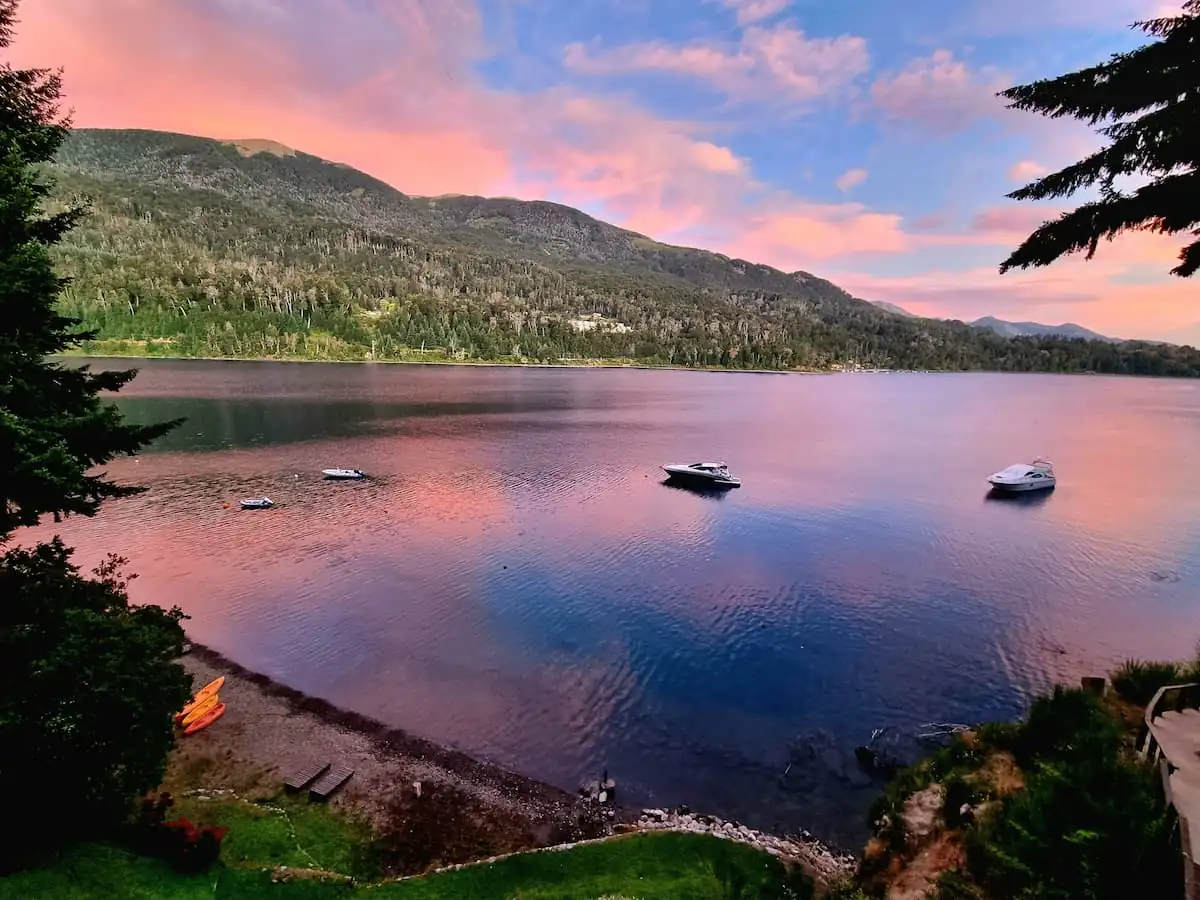 Atardecer sobre el lago Nahuel Huapi con reflejos rosados en Villa La Angostura
