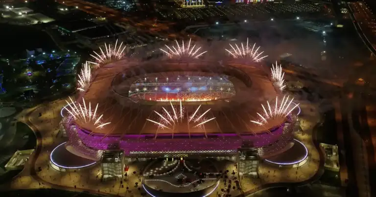 Estadio de fútbol iluminado de noche con fuegos artificiales