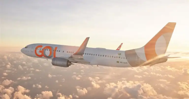 Avión GOL volando sobre nubes al atardecer con cielo dorado
