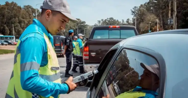 Agente de tránsito tomando datos a conductor junto a vehículos