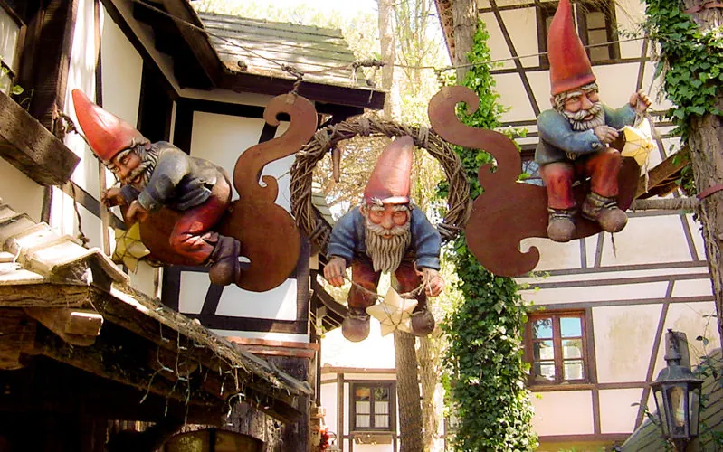 Figuras de gnomo colgantes decorativas en fachada rústica