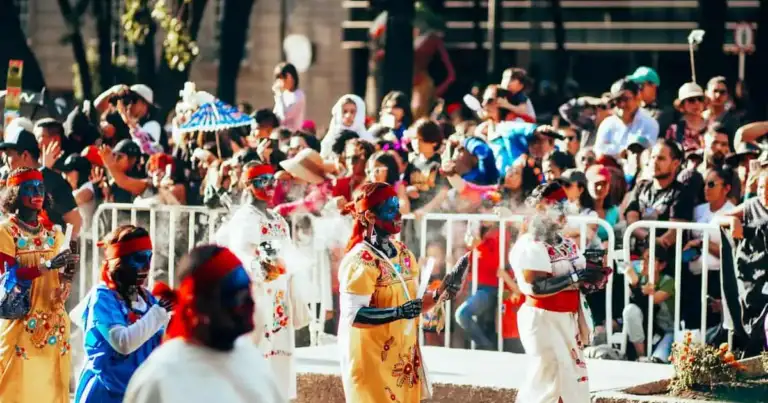 Desfile del Día de los Muertos en México con mujeres maquilladas y vestidas con trajes tradicionales