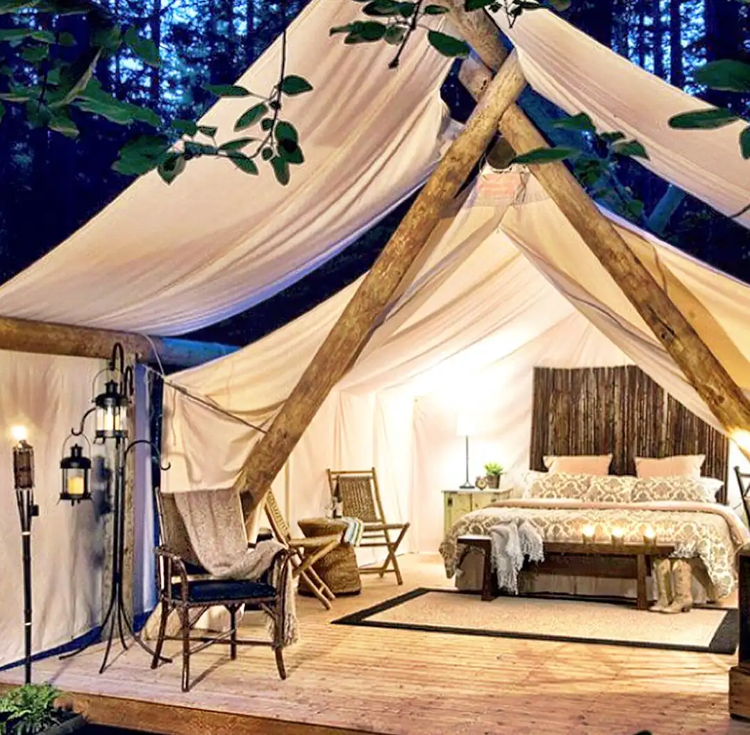 Interior de carpa de glamping lujosa con cama y decoraciones