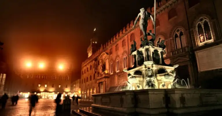 Plaza medieval iluminada con edificios históricos y pórtico con arcos