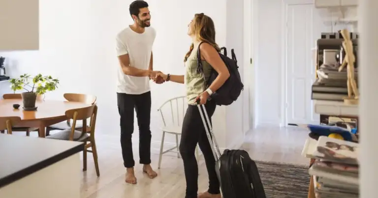 Dos personas dándose la mano en encuentro en interior vivienda