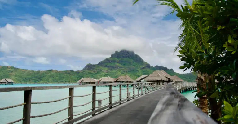 Pasarela de madera hacia bungalows sobre el agua en Bora Bora con el monte Otemanu al fondo
