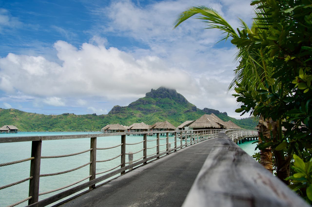 Pasarela de madera hacia bungalows sobre el agua en Bora Bora con el monte Otemanu al fondo