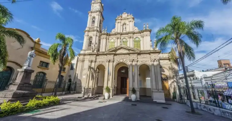 Iglesia colonial blanca con campanario rodeada de palmeras