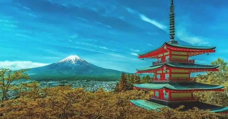 Monte nevado con pagoda roja y construcciones tradicionales en primer plano