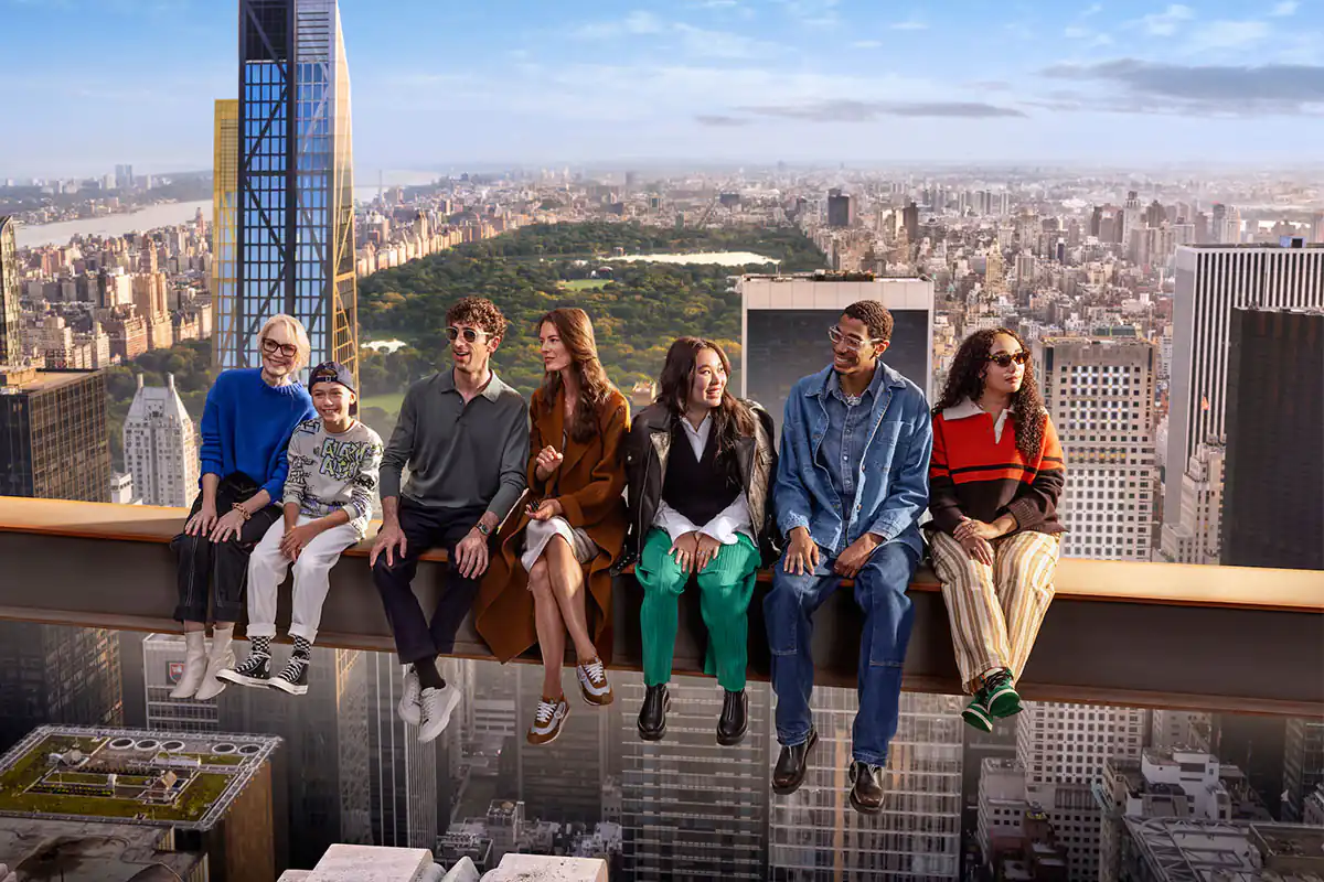 Seis personas sentadas en repisa elevada frente a vista panorámica de ciudad