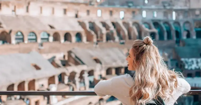 Mujer con gafas de sol observando anfiteatro antiguo de múltiples niveles