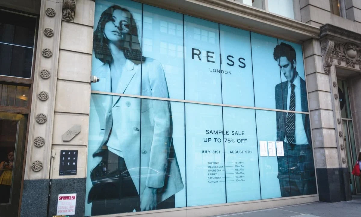 Escaparate de Sample Sale con modelos y anuncio de descuentos REISS