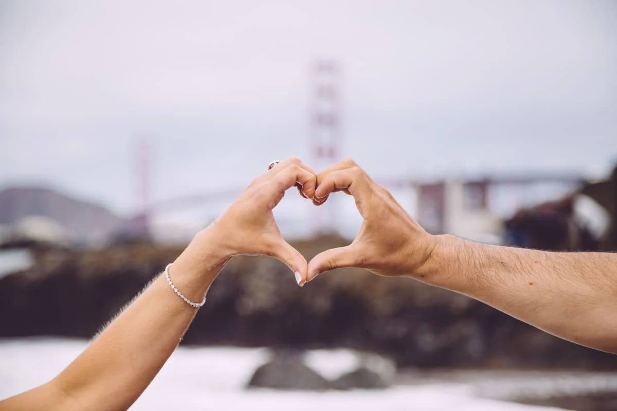 Gesto de corazón con las manos frente al horizonte urbano