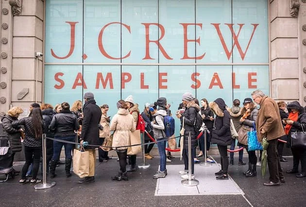 Almacén de Sample Sale J Crew con gente comprando ropa con descuento