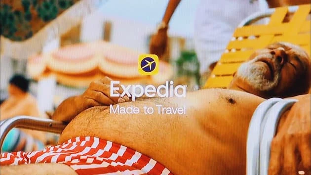 Persona relajándose en la playa con branding de Expedia Made to Travel