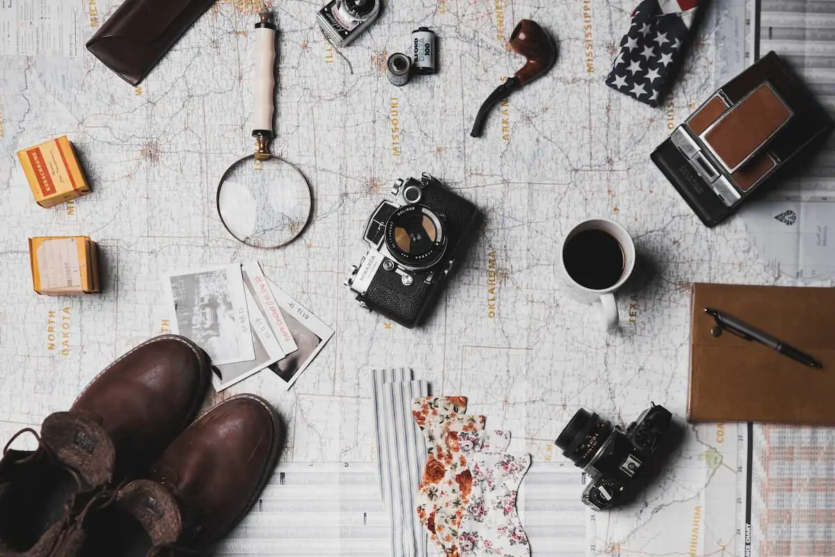 elementos utiles para viajar, lupa, maquina de fotos, botines, libreta de notas