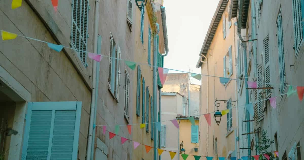Callejuela colorida de barrio antiguo con banderas de colores
