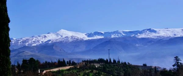 Montaña completamente cubierta de nieve contra cielo azul