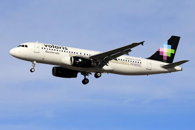 Avión de Volaris en pleno vuelo con cielo despejado de fondo.