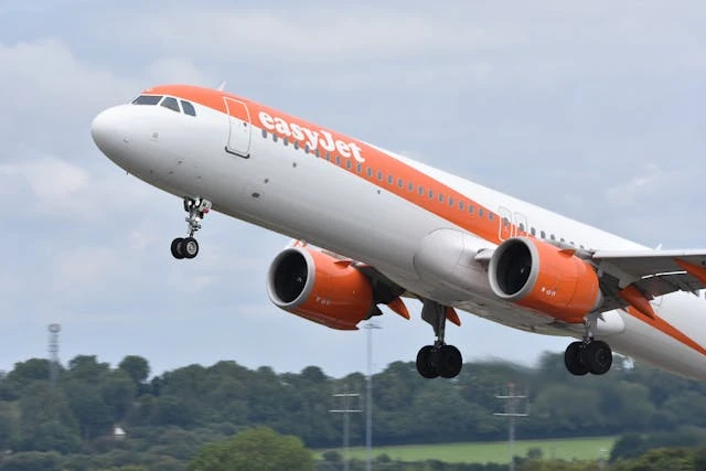 Avión de easyJet despegando en un aeropuerto con cielo nublado.