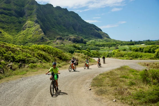Tour guiado en bicicletas eléctricas por Kualoa Ranch, combinando ejercicio, historia y paisajes Grupo de visitantes recorriendo Kualoa Ranch en bicicletas eléctricas con vista al océano