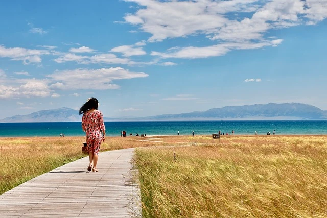 creditos: pixabay Escala ideal para una escapada breve a la playa o un paseo relajante Mujer caminando hacia el mar por un sendero de madera en una escala larga