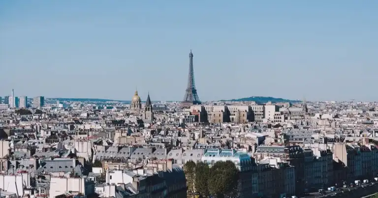 Vista panorámica de París con la Torre Eiffel al fondo en un día despejado.
