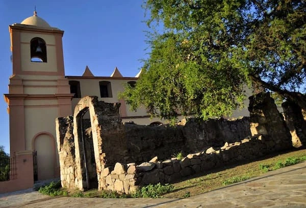 Capilla histórica con campanario y ruinas de piedra