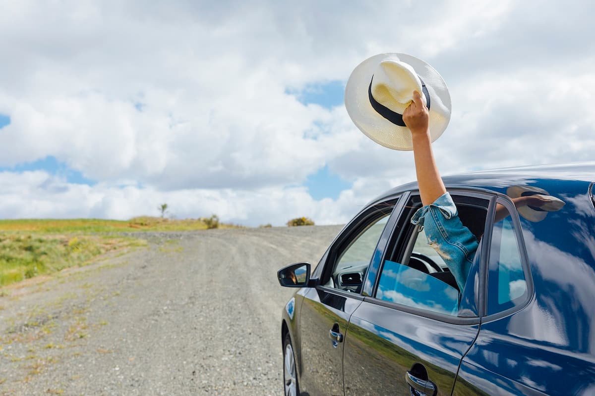 Mujer saliendo de viaje por la ruta